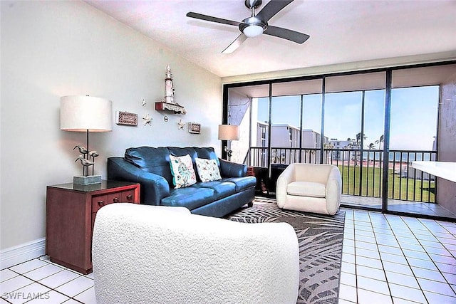 living area with a ceiling fan, floor to ceiling windows, light tile patterned flooring, and baseboards