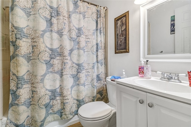 bathroom featuring toilet, vanity, and curtained shower