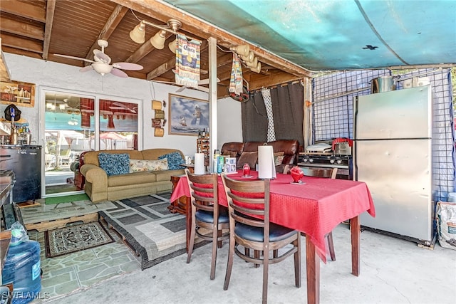 dining area with ceiling fan, concrete floors, and lofted ceiling