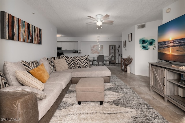 living room with a textured ceiling and ceiling fan