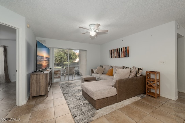 tiled living room with a textured ceiling and ceiling fan