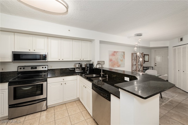 kitchen with white cabinets, kitchen peninsula, stainless steel appliances, and sink