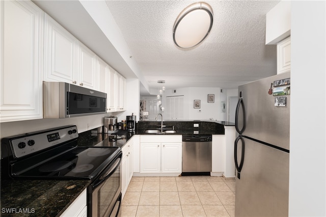 kitchen featuring white cabinets, appliances with stainless steel finishes, a textured ceiling, and sink