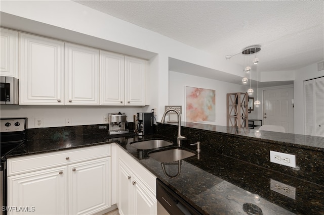 kitchen featuring white cabinets, dark stone counters, sink, and stainless steel appliances