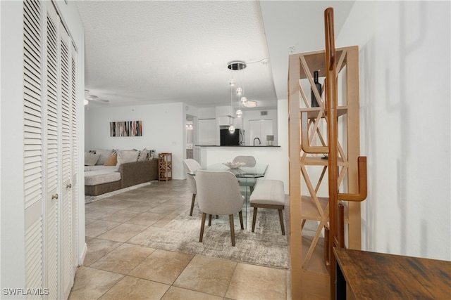 dining room featuring a textured ceiling, ceiling fan, and light tile patterned floors