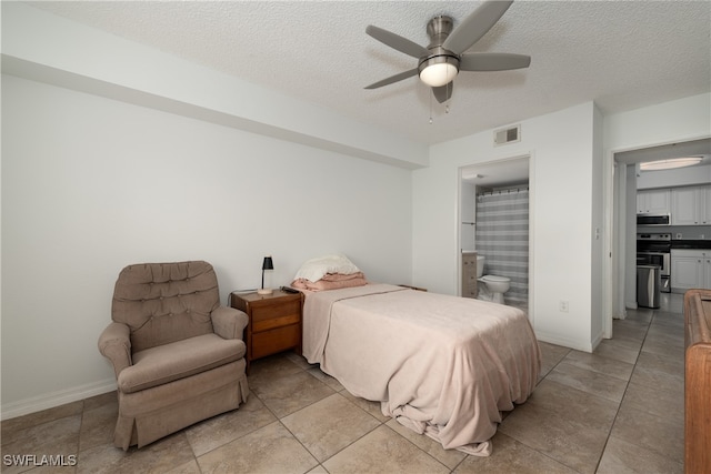 bedroom with connected bathroom, light tile patterned flooring, a textured ceiling, and ceiling fan