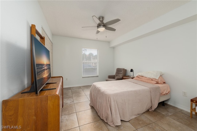 tiled bedroom featuring a textured ceiling and ceiling fan