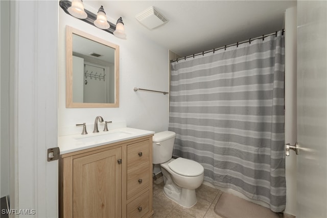 bathroom featuring toilet, vanity, and tile patterned floors