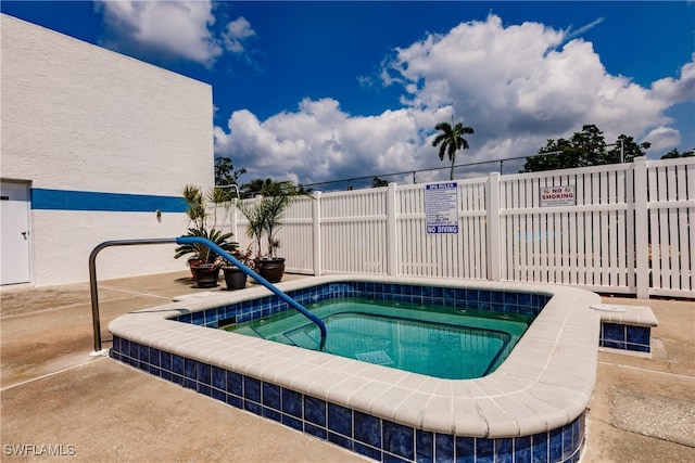 view of swimming pool featuring a hot tub