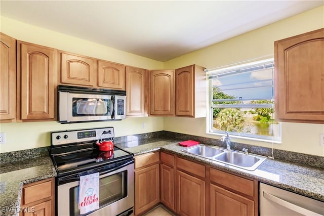 kitchen featuring sink, dark stone counters, and appliances with stainless steel finishes