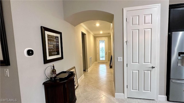 hall featuring crown molding and light tile patterned flooring