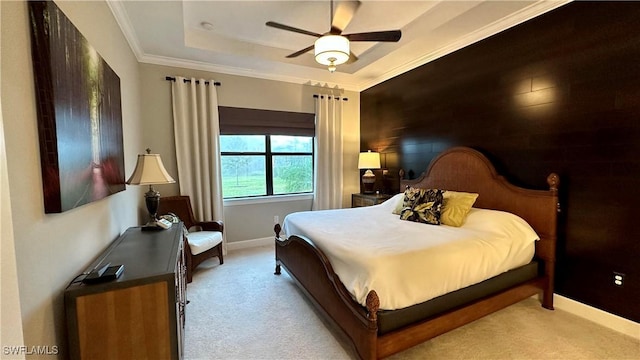 carpeted bedroom with ceiling fan, a raised ceiling, and ornamental molding