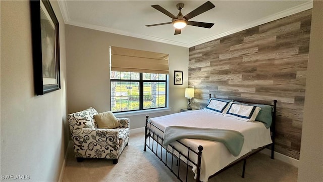 bedroom featuring light carpet, ceiling fan, an accent wall, ornamental molding, and wood walls