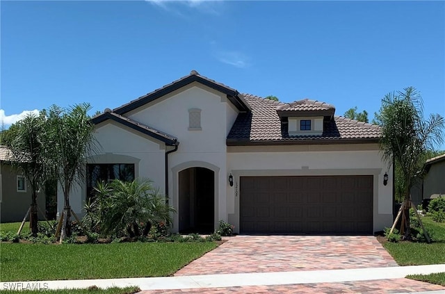 mediterranean / spanish house with a garage and a front yard