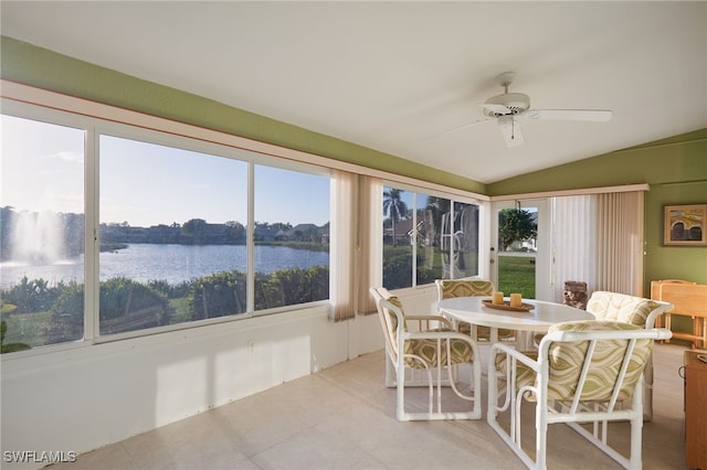 sunroom with ceiling fan, a water view, a wealth of natural light, and vaulted ceiling