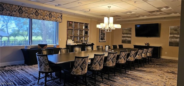 dining room with a raised ceiling, a chandelier, and ornamental molding