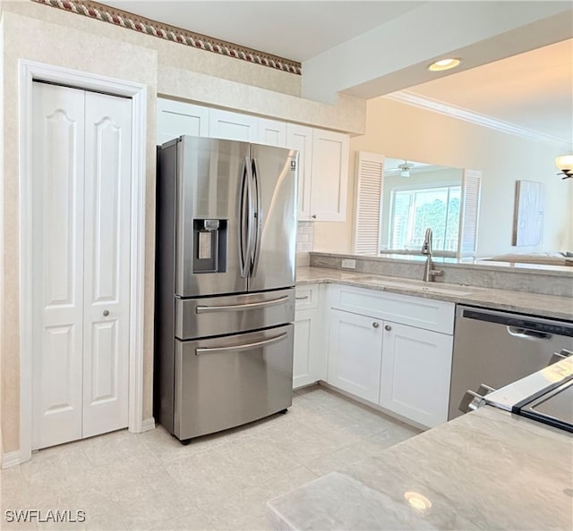 kitchen with ceiling fan, sink, stainless steel appliances, crown molding, and white cabinets