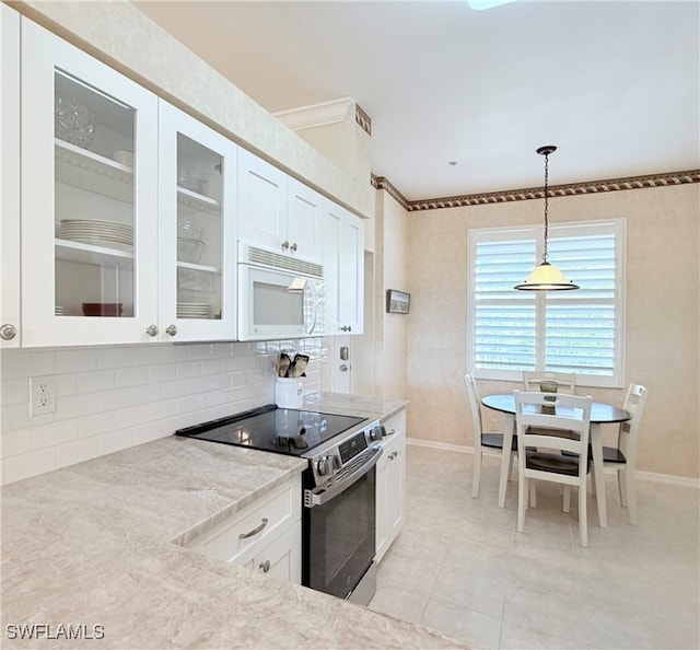 kitchen featuring light stone countertops, hanging light fixtures, backsplash, stainless steel electric stove, and white cabinets