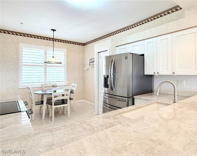 kitchen with range, white cabinets, sink, hanging light fixtures, and stainless steel fridge with ice dispenser