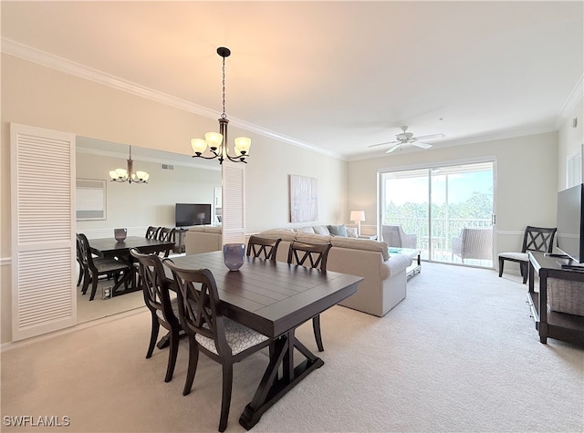 dining space featuring ceiling fan with notable chandelier, crown molding, and light carpet