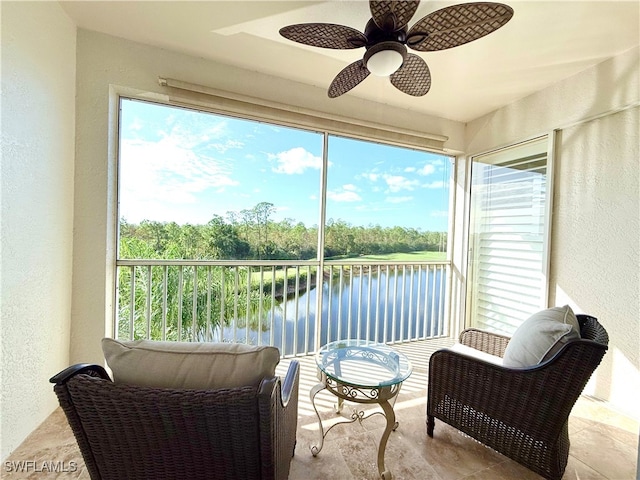 sunroom / solarium with a water view and ceiling fan