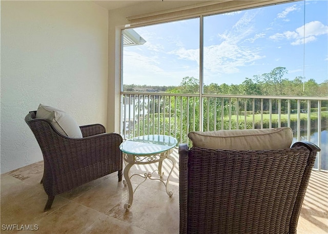 sunroom / solarium featuring a water view