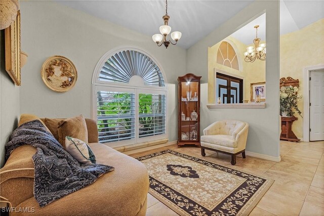 sitting room featuring light tile patterned floors, high vaulted ceiling, and an inviting chandelier