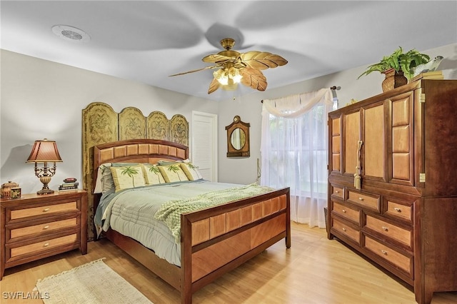 bedroom with ceiling fan, light wood-type flooring, and a closet