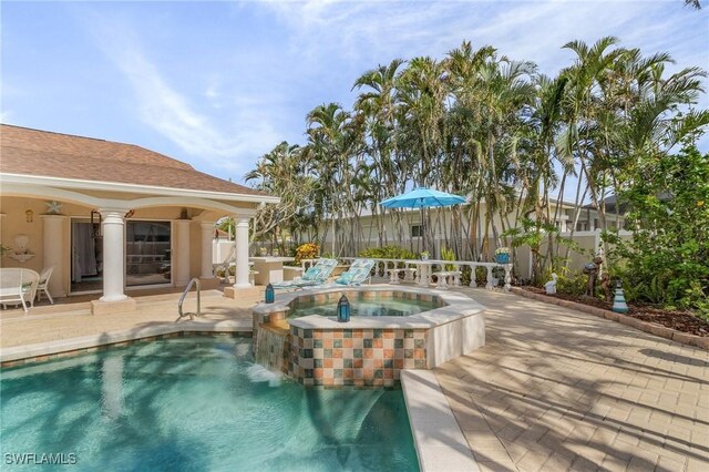 view of pool featuring a patio area and an in ground hot tub