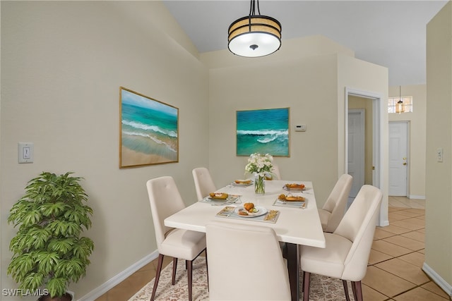 dining room featuring vaulted ceiling and light tile patterned floors