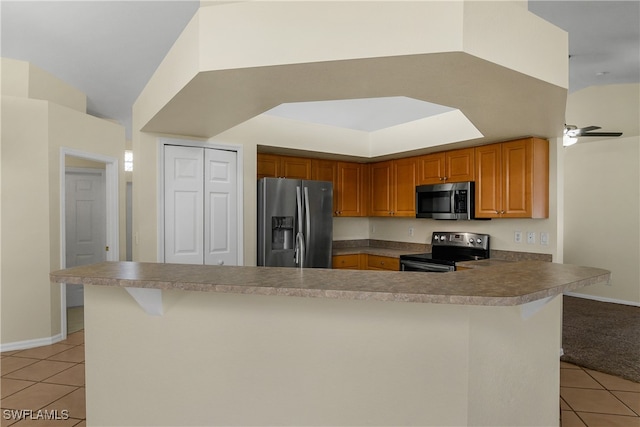 kitchen featuring stainless steel appliances, kitchen peninsula, ceiling fan, a breakfast bar area, and light tile patterned floors