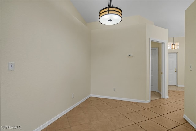 spare room featuring light tile patterned floors and vaulted ceiling