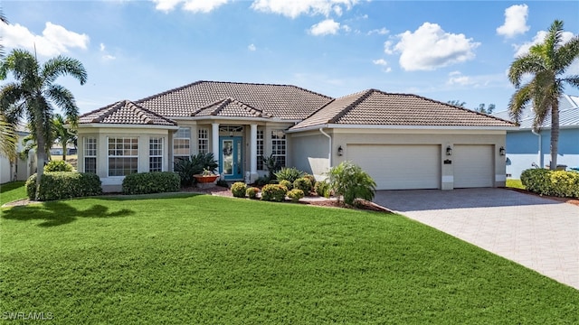 mediterranean / spanish home featuring a front lawn and a garage