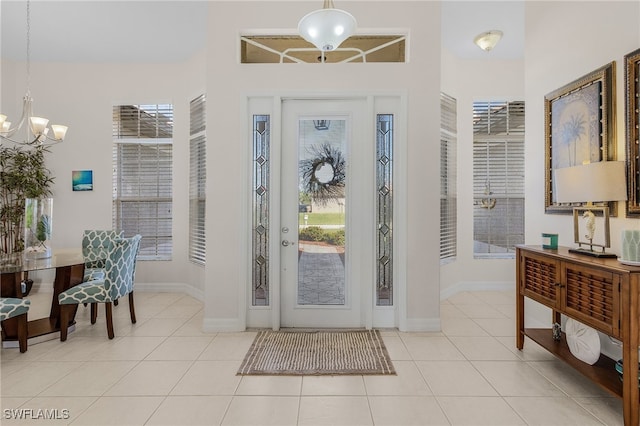 entryway with light tile patterned floors and an inviting chandelier