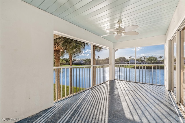 unfurnished sunroom featuring a water view, ceiling fan, and wooden ceiling