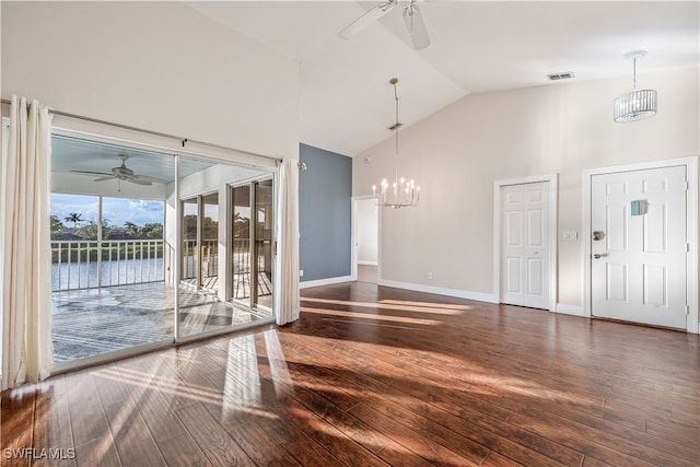 unfurnished living room featuring dark hardwood / wood-style flooring, high vaulted ceiling, a water view, and ceiling fan with notable chandelier