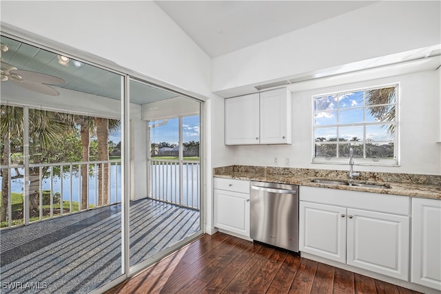 kitchen with vaulted ceiling, white cabinets, dark wood-type flooring, stainless steel dishwasher, and a water view