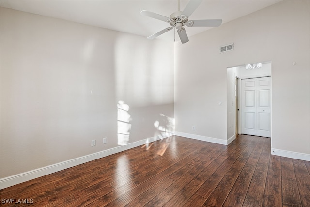 empty room featuring dark wood-type flooring and ceiling fan