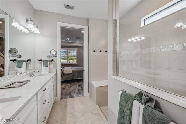 bathroom with a tile shower, vanity, and tile patterned flooring