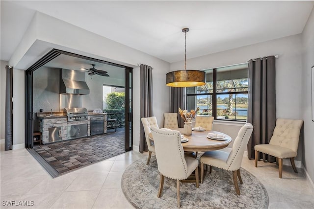 dining area featuring a ceiling fan, tile patterned flooring, and baseboards