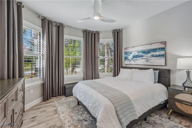 bedroom featuring multiple windows, ceiling fan, and light wood-type flooring