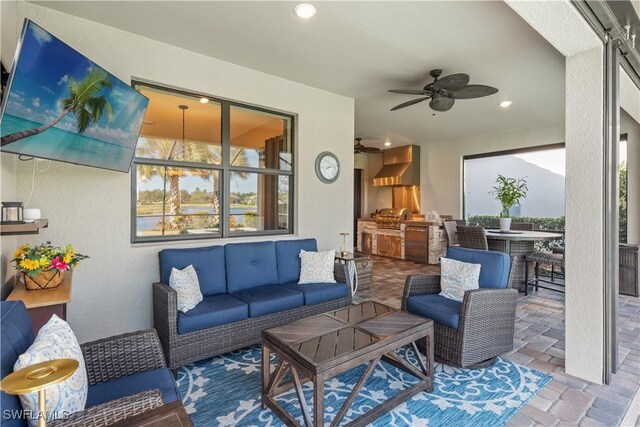 view of patio / terrace with an outdoor hangout area, exterior bar, an outdoor kitchen, area for grilling, and ceiling fan