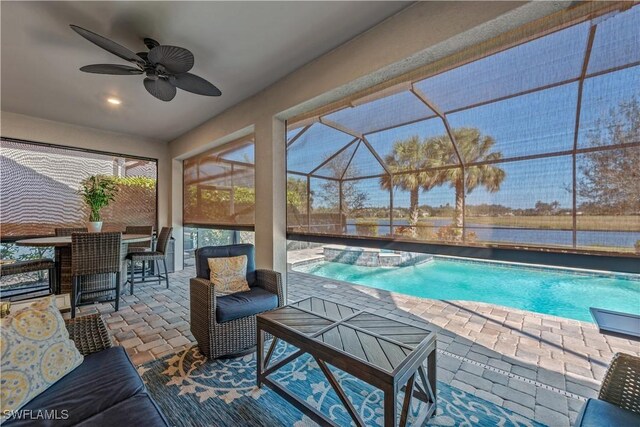 view of swimming pool with a bar, a patio, ceiling fan, and glass enclosure