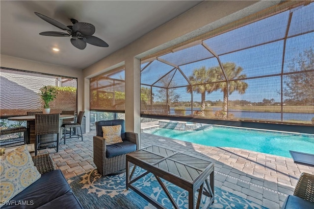 view of pool featuring a pool with connected hot tub, a ceiling fan, a lanai, a patio, and outdoor dining area