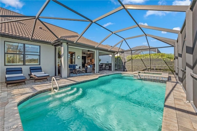 view of swimming pool featuring glass enclosure, a pool with connected hot tub, a patio area, a ceiling fan, and outdoor dining space