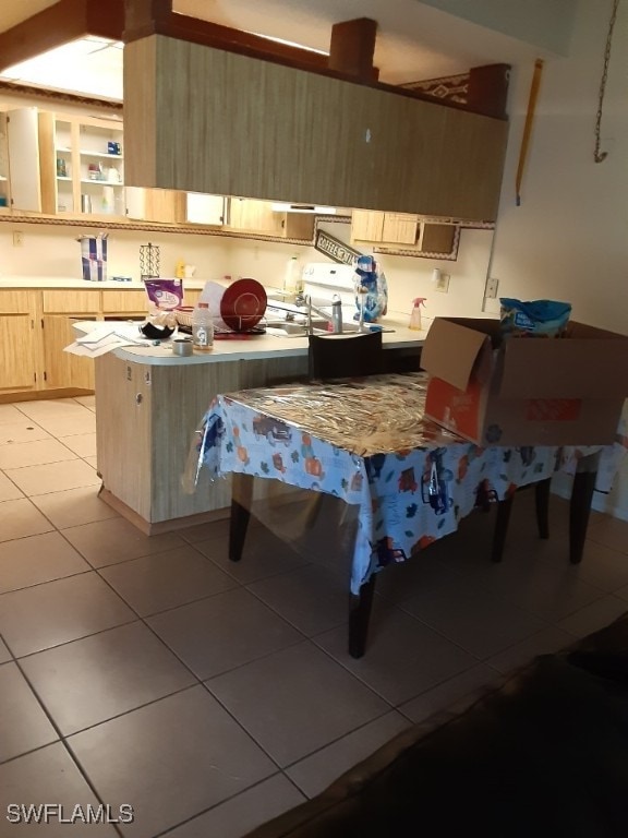 kitchen featuring light brown cabinets, kitchen peninsula, and light tile patterned floors