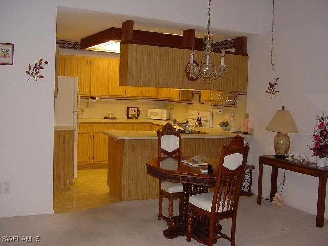 kitchen featuring range, kitchen peninsula, and a notable chandelier