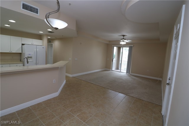 kitchen featuring white cabinetry, light carpet, white fridge with ice dispenser, sink, and ceiling fan