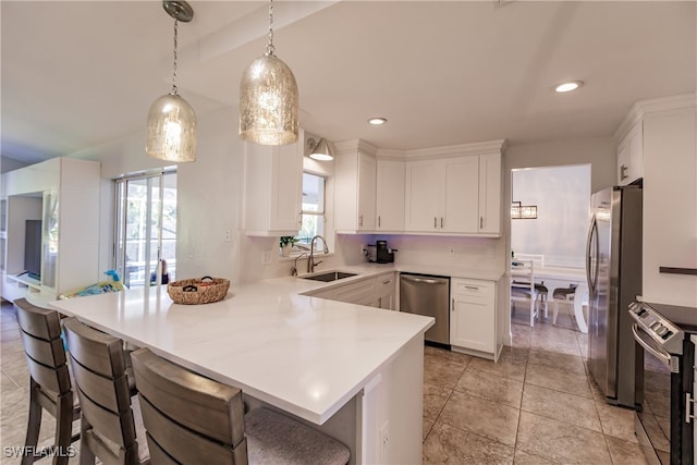 kitchen with appliances with stainless steel finishes, white cabinetry, plenty of natural light, and sink