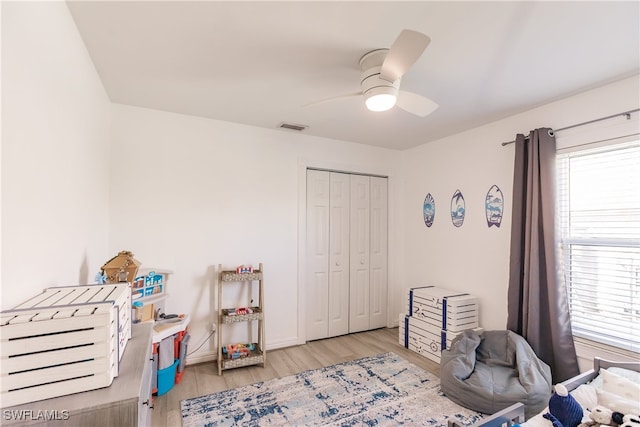 bedroom featuring light hardwood / wood-style flooring, a closet, and ceiling fan